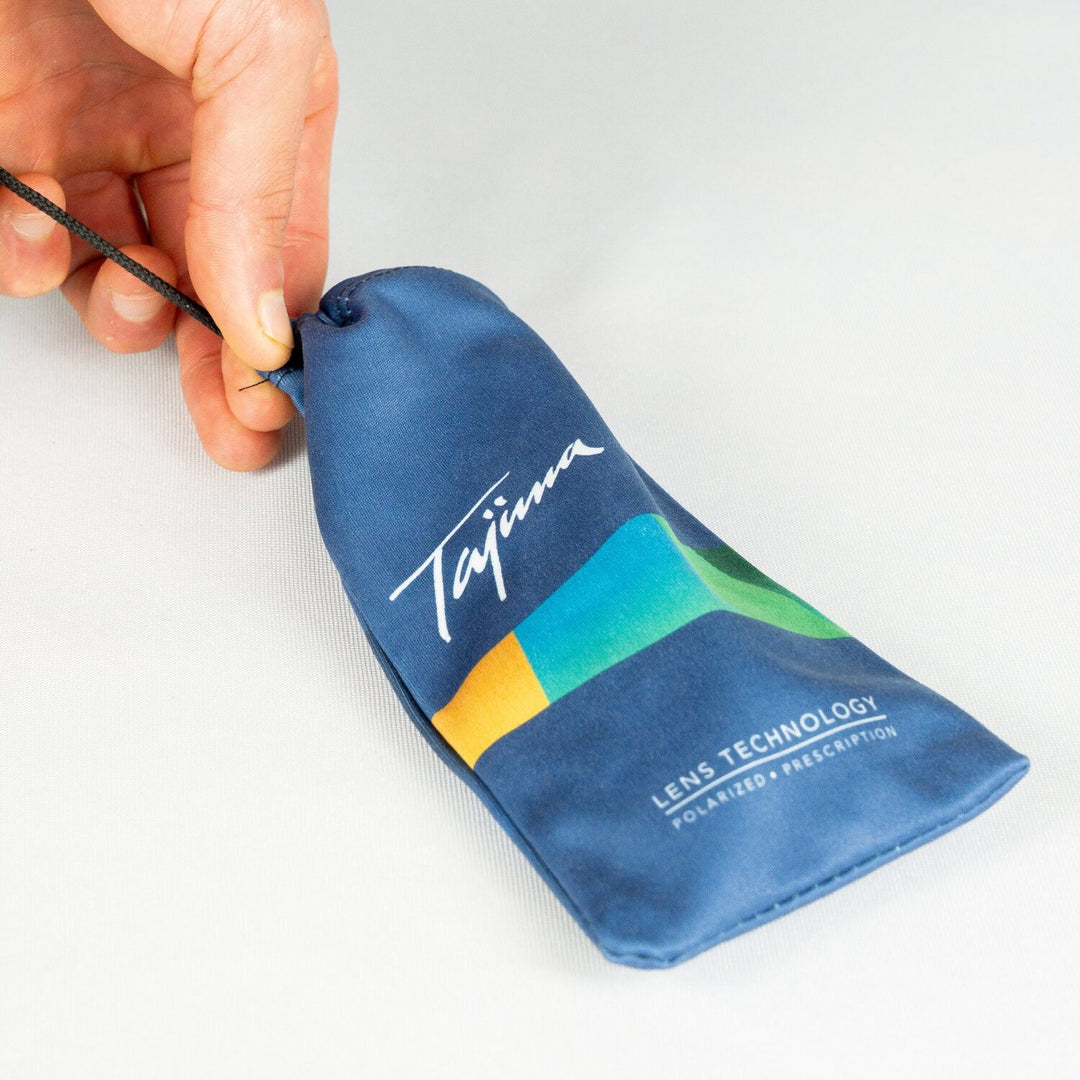 Pulling drawstring to close Tajima microfiber sunglass storage pouch