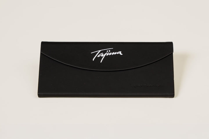 Tajima foldable sunglass case closed flat showing Tajima logo and Tajima-Direct.com branding