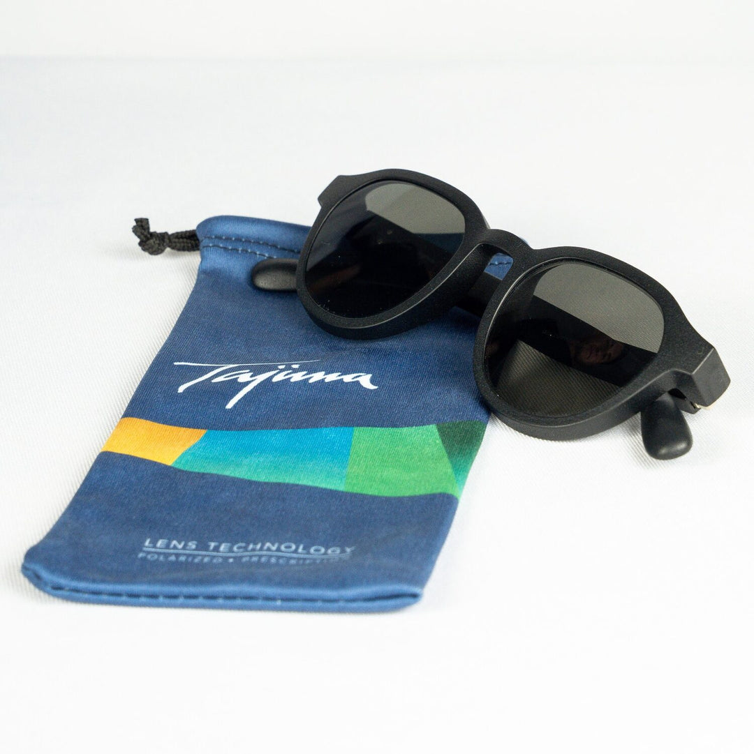 Sunglasses resting on Tajima microfiber storage pouch showing size reference